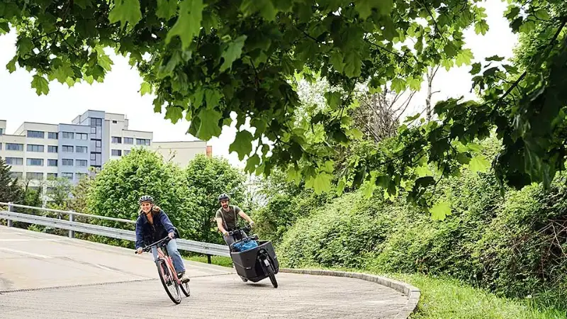 Lastenrad und Fahrrad fahren um die Kurve