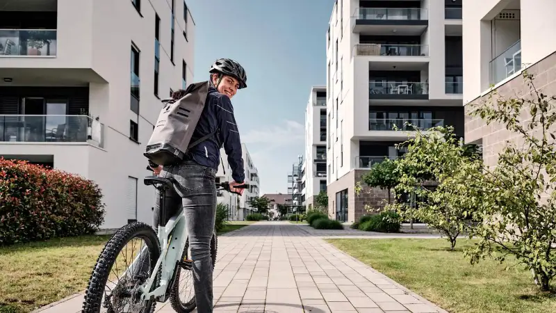 JobRadlerin mit Mountainbike in einer Häuserschlucht