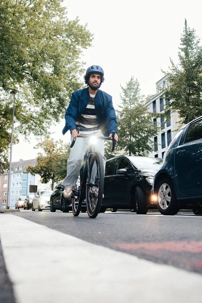 Fahrradfahrer auf einem Radweg neben einer Autoschlange