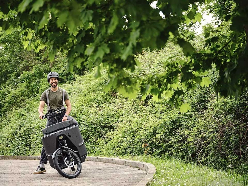 Ein JobRadler auf dem Lastenrad steht in einer Kurve