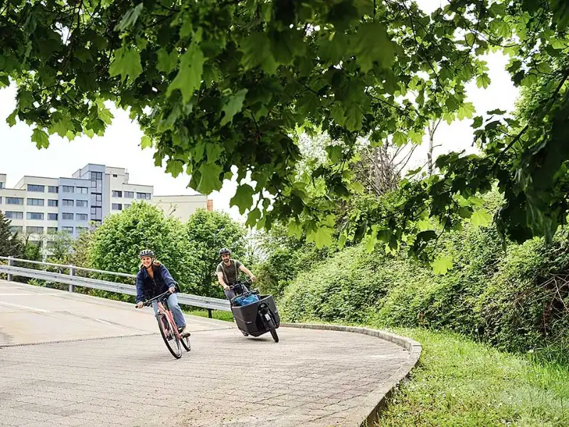 Lastenrad und Fahrrad fahren um die Kurve