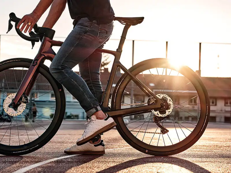 Fahrradfahrer steht auf urbanem Sportplatz im Sonnenuntergang