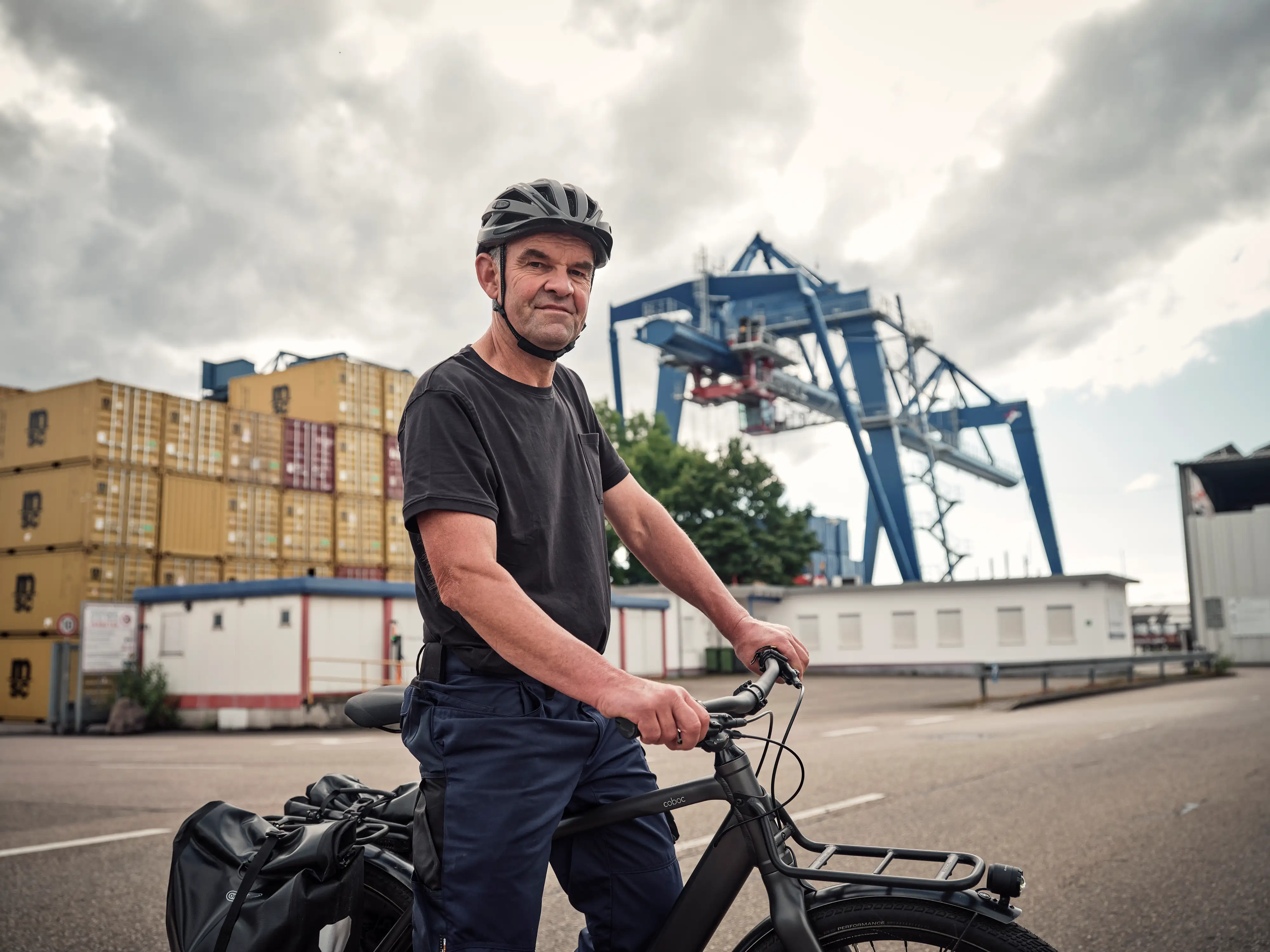 JobRadler steht am Containerhafen und blickt selbstbewusst in die Kamera